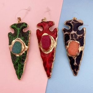 Détail de pendentifs flèches bohèmes en vert, rouge et léopard avec bordure métallique
