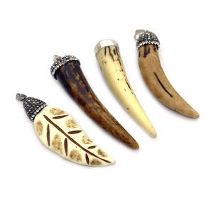 Resin leaf and horn pendants with rhinestone caps for DIY necklaces on white background