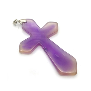Dettaglio macro di un ciondolo a croce in agata viola naturale con gancio in metallo argento