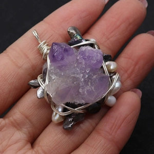 Detailaufnahme eines handgefertigten Amethyst-Perlenanhängers mit Drahtumwicklung
