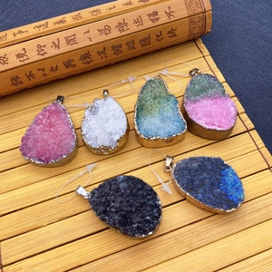 Macro detail of multicolored druzy stone teardrop pendants on a natural bamboo mat