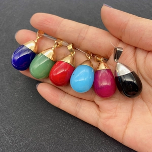 Close-up of colorful teardrop natural stone pendants with gold and silver plated caps