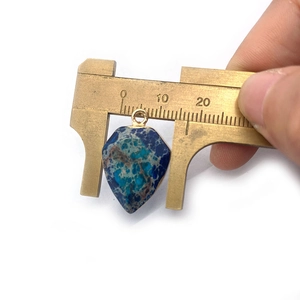 Medición manual de colgante de piedra natural con borde dorado y tonos azul y verde