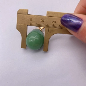 Macro detail of tear drop green agate pendant width measured by a metal caliper