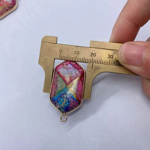 Gros plan mesurant la largeur de 21mm d'un pendentif hexagonal en pierre naturelle