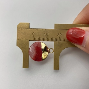 Measuring a 15mm round natural stone pendant with gold metal and red marble resin details