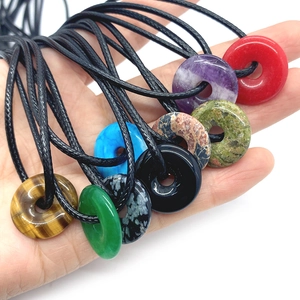 Assorted natural gemstone donut pendants including tiger eye and amethyst with black cord