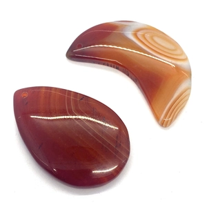 Natural red agate stone pendants in teardrop and crescent shapes with unique banded patterns