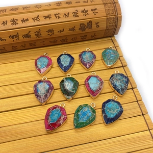 Set de 11 colgantes de piedra facetada con bordes metálicos sobre esterilla de bambú