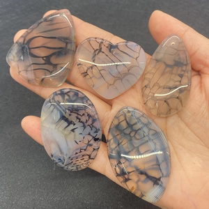 Close-up of five grey dragon vein agate pendants in varied shapes with pre-drilled holes