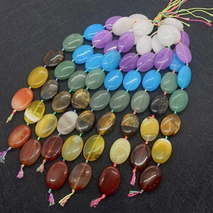 Macro detail of mixed natural gemstone oval beads including agate and tiger eye for DIY jewelry