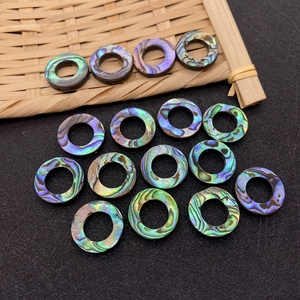 Detailed view of iridescent abalone shell donut beads with vibrant natural textures