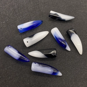 Macro detail of horn-shaped agate stone pendants with gradient blue and black finish