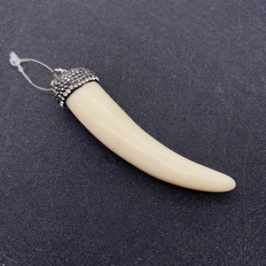 Macro shot of chili-shaped faux bone pendant with a rhinestone-studded dark metal cap