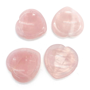 Piedras de masaje de cuarzo rosa natural en forma de corazón sobre fondo blanco puro