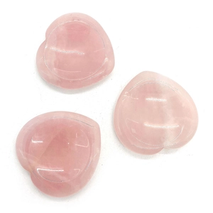 Detalle de tres piedras de cuarzo rosa en forma de corazón con superficie cóncava lisa