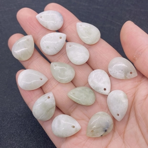 Macro shot of 14 light green and white teardrop stones with pre-drilled holes for jewelry