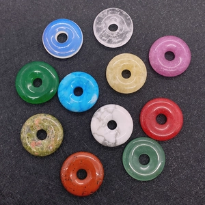 Macro view of ten colorful round natural stone pendants on a black matte background