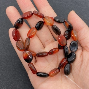 Vue détaillée de perles ovales en agate naturelle 10x14mm rouge et noir pour bijoux DIY