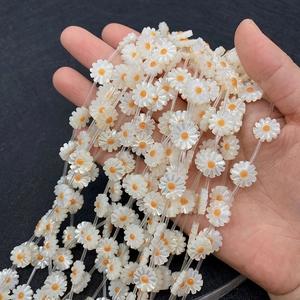 Dettaglio di perline a forma di margherita in conchiglia naturale per gioielli fai-da-te