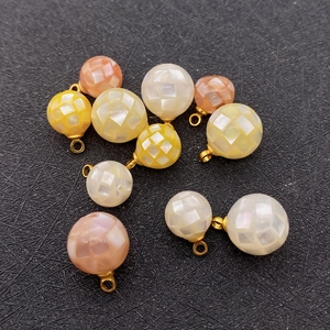 Macro detail of natural sea shell mosaic ball pendants with golden rings for DIY jewelry