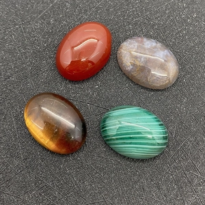 Macro detail of oval cabochon gemstones including tiger eye and red agate for jewelry DIY