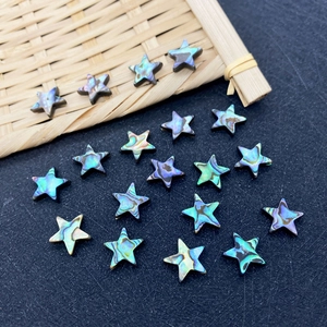 Macro detail of natural abalone shell star-shaped beads with iridescent luster for DIY