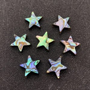 Macro detail of seven iridescent star-shaped abalone shell beads for DIY jewelry making