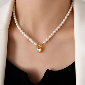 Primer plano de un collar de perlas de agua dulce con un colgante de corazón dorado