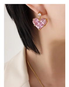 Nahaufnahme der rosa herzförmigen Kristallohrringe mit Goldbeschichtung