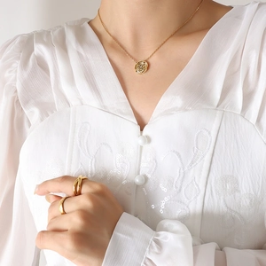 Elegante collana a rosa dorata con inserto in conchiglia e anelli sovrapponibili sottili