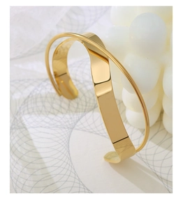 Detailed view of polished 18K gold plated cross structure cuff bracelet with a glossy finish