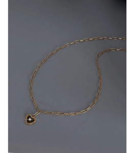 Detail of 18K gold plated heart pendant with black enamel inlay on a paperclip chain