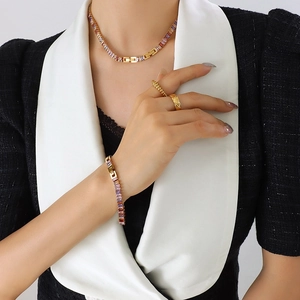 Elegant gold jewelry set with colorful baguette zircons featuring necklace and bracelet
