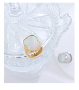 Macro di un anello irregolare placcato oro 18 carati con intarsio in madreperla bianca