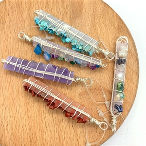 Detailed view of handmade wire-wrapped crystal pendants with colorful crushed stones