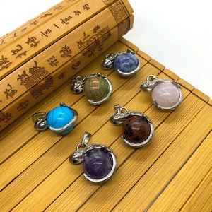 Close-up of assorted natural round stone pendants on traditional bamboo mat surface