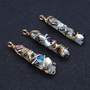 Vue détaillée de pendentifs en perles baroques faits main avec fil doré sur fond texturé sombre