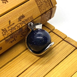 Vue détaillée du pendentif sphère en pierre bleue étoilée avec fermoir en argent