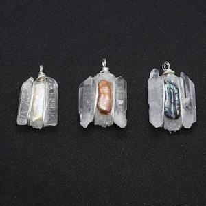 Macro shot of handmade wire wrapped crystal pendants with baroque pearls on black texture
