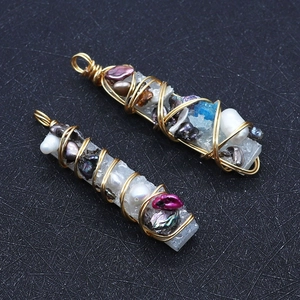 Détail d'un pendentif artisanal avec perles d'eau douce, résine et fil doré entrelacé