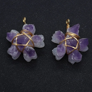 Detail of natural purple crystal flower pendants with handcrafted gold wire wrapping