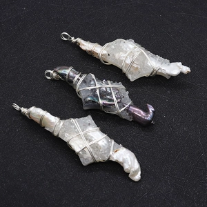 Detailed close-up of handmade wire-wrapped baroque pearl and crystal cross pendants