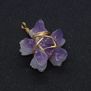 Detailed macro view of handmade purple crystal flower pendant with gold wire wrapping