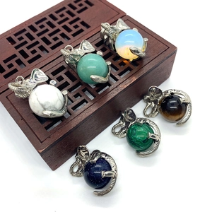 Elephant-shaped natural gemstone pendants with silver plated frames on a vintage wood box