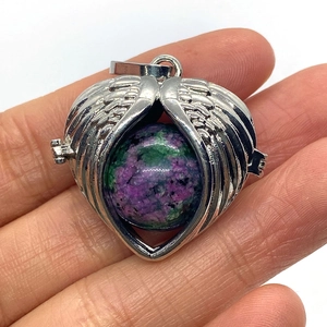 Macro detail of heart-shaped angel wing locket with ruby in zoisite gemstone