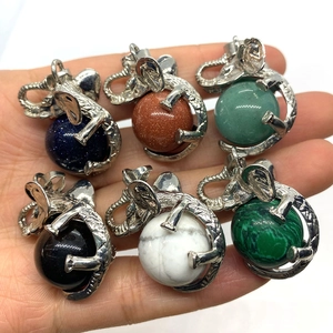 Elephant-shaped gemstone pendants in six natural stones held in a palm for scale
