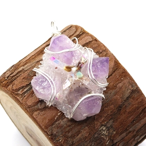 Natural purple amethyst cluster pendant with handmade wire wrap on wood background