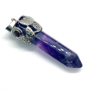 Makroaufnahme von Amethyst-Anhänger mit verzierter silberner Metallkappe aus Blatt