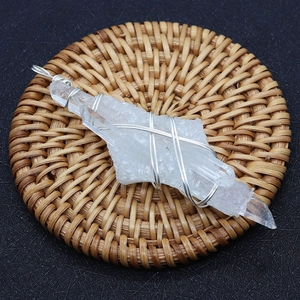 Colgante de cristal blanco natural con alambre plateado sobre base trenzada